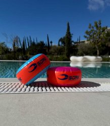 Rosa/oranga runda armpuffar som lätt syns i vattnet.