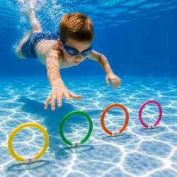 Barn dyker i pool och plockar upp färgglada dykringar med vit tyngd från botten för lek och simträning
