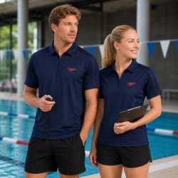 Speedo pikétröja i mörkblått funktionsmaterial på man och kvinna vid bassängkanten.