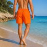 Bekväma orangea badshorts för herr med nätinnerbyxa och bakficka, perfekta för stranden och simhallen.