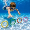 Barn dyker i pool och plockar upp färgglada dykringar med vit tyngd från botten för lek och simträning