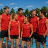Sex personer i röda Speedo funktionslinnen vid en utomhuspool