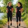 Två kvinnor springer i svart rosa träningströjor för dam från Victoria Dronsfield